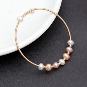 Close-up of golden spiral wire bracelet with multi-colored natural freshwater pearls