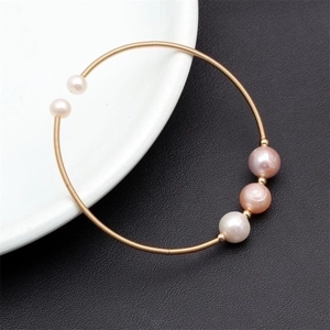 Detail of gold thin-wire bracelet with five colorful natural freshwater pearls