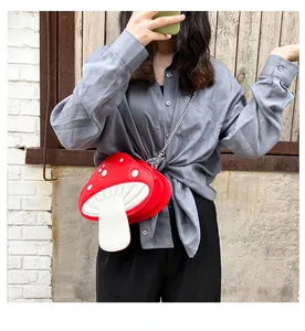 Detail shot of a red mushroom crossbody bag with white dots and a metal chain strap