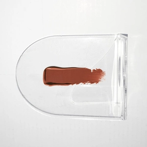 Brown-red lipstick swatches on a transparent acrylic makeup mixing palette