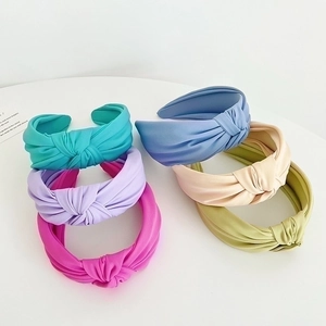 Selection of colorful knotted velvet headbands in blue, purple, pink, and green tones