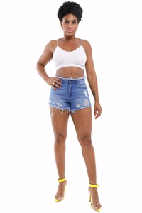 Detail of high waisted blue ripped denim shorts with frayed hems and distressed finish