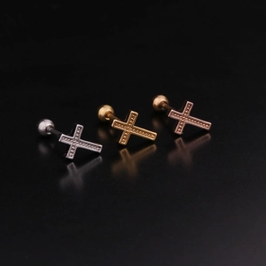 Macro shot of cross ear studs in silver, gold, and rose gold with zircon stones