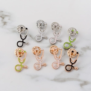Detail view of colorful stethoscope enamel pins with metal butterfly backs on marble