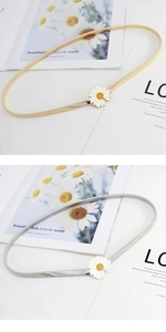 Detailed macro view of white daisy metal buckle and elastic snake bone chain belt