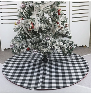 Vue détaillée du tapis de sapin de Noël à carreaux noirs et blancs avec bordure rouge