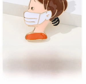 Close-up of a cartoon girl pin wearing a mask with gold plating and enamel finish