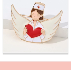 Detailed shot of an angel nurse enamel brooch with white wings and red heart on white steps