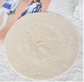 Detail shot of a beige wool beret for girls on a lace background with a minimalist style