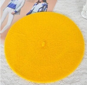 Detailed view of flat lay bright yellow wool beret hat on lace tablecloth background