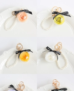 Macro detail of eternal rose keychains in transparent globes with pearl chains