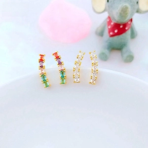 Close-up of gold ear climbers featuring multi-color and white square zirconia stones