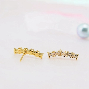 Macro detail of gold-plated hoop earrings featuring a row of square cubic zirconia stones