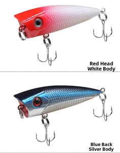 Close-up of red head white body and blue back silver body popper lures with 3D eyes