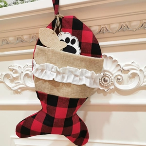 Detailsicht der fischförmigen Weihnachtssocke mit rot-schwarzem Karomuster und Knochendeko
