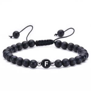 Detail of 6mm matte agate bead bracelet with woven cord and letter F charm