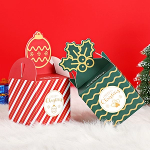 Red and green Christmas gift boxes with festive patterns on white faux fur background