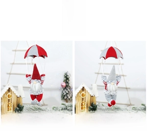 Details von roten und grauen gestrickten Weihnachtswichteln, die an Fallschirmen hängen