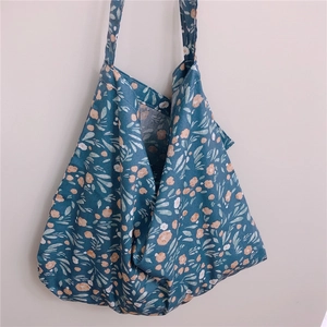 Floral cotton tote bag detail featuring orange blossoms on deep blue soft canvas fabric