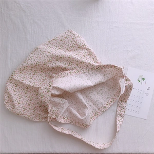 Detail of floral pattern on soft cotton tote bag with pink flowers and green leaves