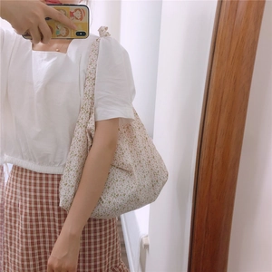 Detailed close-up of a floral cotton shoulder bag with soft pink and green patterns