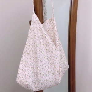 Detail of floral tote bag showing delicate pink flower print on white cotton fabric