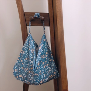 Detailed macro of vintage floral tote bag texture hanging on a wooden hook