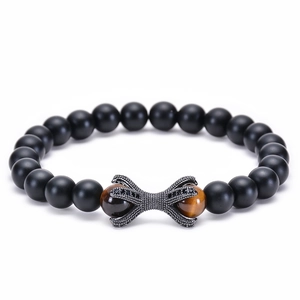 Macro shot of matte onyx beads with tiger eye stones and a black pavé dragon claw charm