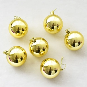 Set de seis bolas de Navidad doradas brillantes con cordones para colgar en fondo blanco