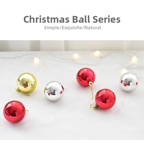 Detalle de bolas de Navidad brillantes en rojo, plata y oro sobre piel sintética blanca