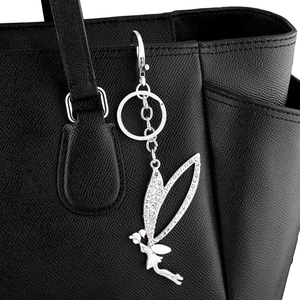 Elegant silver fairy butterfly keychain with crystal rhinestones hanging on black leather bag