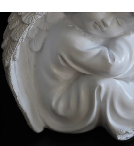 Vue détaillée d'une sculpture d'ange en résine blanche avec textures d'ailes fines