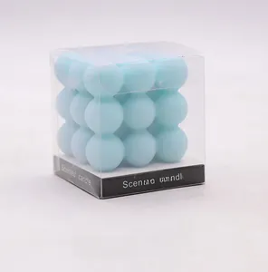 Macro detail van een lichtblauwe kubus geurkaars in een transparante PVC geschenkdoos