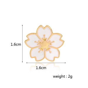 Detail shot of a cherry blossom enamel brooch with gold trim measuring 1.6cm by 1.6cm