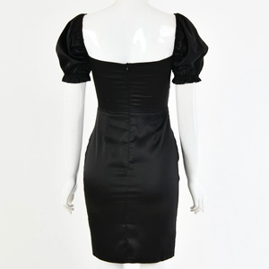 Detail view of a black satin mini dress with puffy sleeves and an elegant open back design