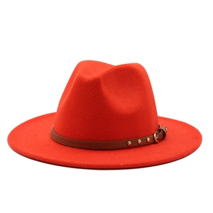 Detailed view of red felt fedora with brown leather band and gold metal buckle detail