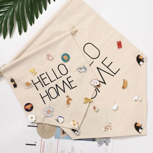 Detail view of two beige canvas banner flags with HELLO HOME print for pin collection