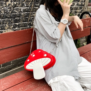 Detail of red and white mushroom-shaped cross-body bag with silver metal chain