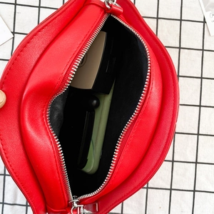 Detail view showing red heart-shaped bag interior capacity with metal zipper