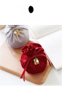 Detail of velvet wedding favor bags with silk bows and golden double happiness charms