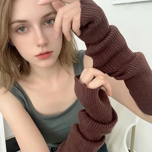 Close-up of dark brown knitted arm sleeves featuring ribbed cuffs and thumb hole design