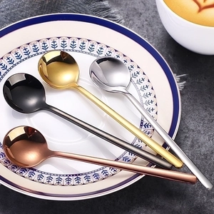 Polished stainless steel coffee spoons in gold, silver, black, and rose gold on a plate