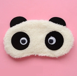 Cute plush panda sleep mask with soft black and white fur on a pink background