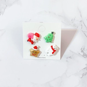 Close-up of four acrylic Christmas studs featuring Santa, tree, star, and polar bear