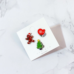 Detailed close-up of acrylic Christmas brooches featuring gingerbread man and Xmas tree