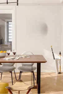 Detail of a pink quartz wall clock with Arabic numerals shown in a warm dining room scene