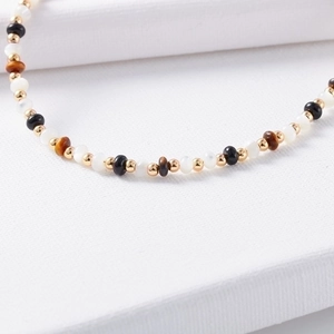 Beaded vintage necklace with gold beads, white pearls, onyx, and tiger eye stones