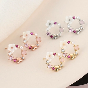 Floral hoop earrings with shell petals and pearls in silver, rose gold, and gold finishes