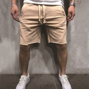 Detail of men's casual apricot shorts with drawstring waist and raw edge hem design
