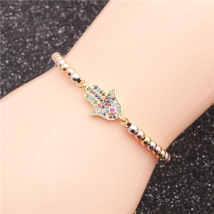 Dettaglio macro del bracciale con Mano di Fatima e zirconi colorati sul polso della modella